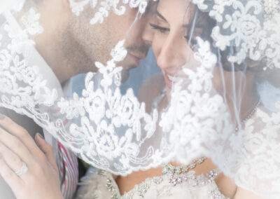 CineCrown wedding photography A bride and groom embracing under a veil.